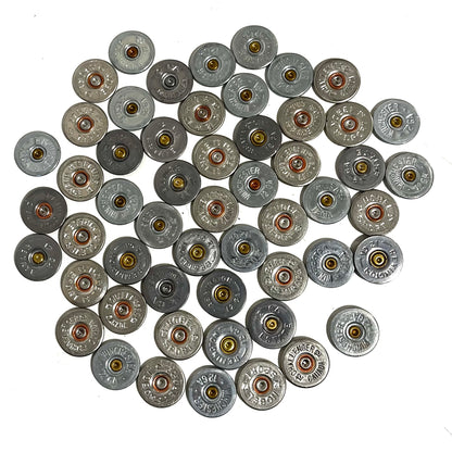 A pile of silver shotgun shell slices with various headstamps and gold or copper primers