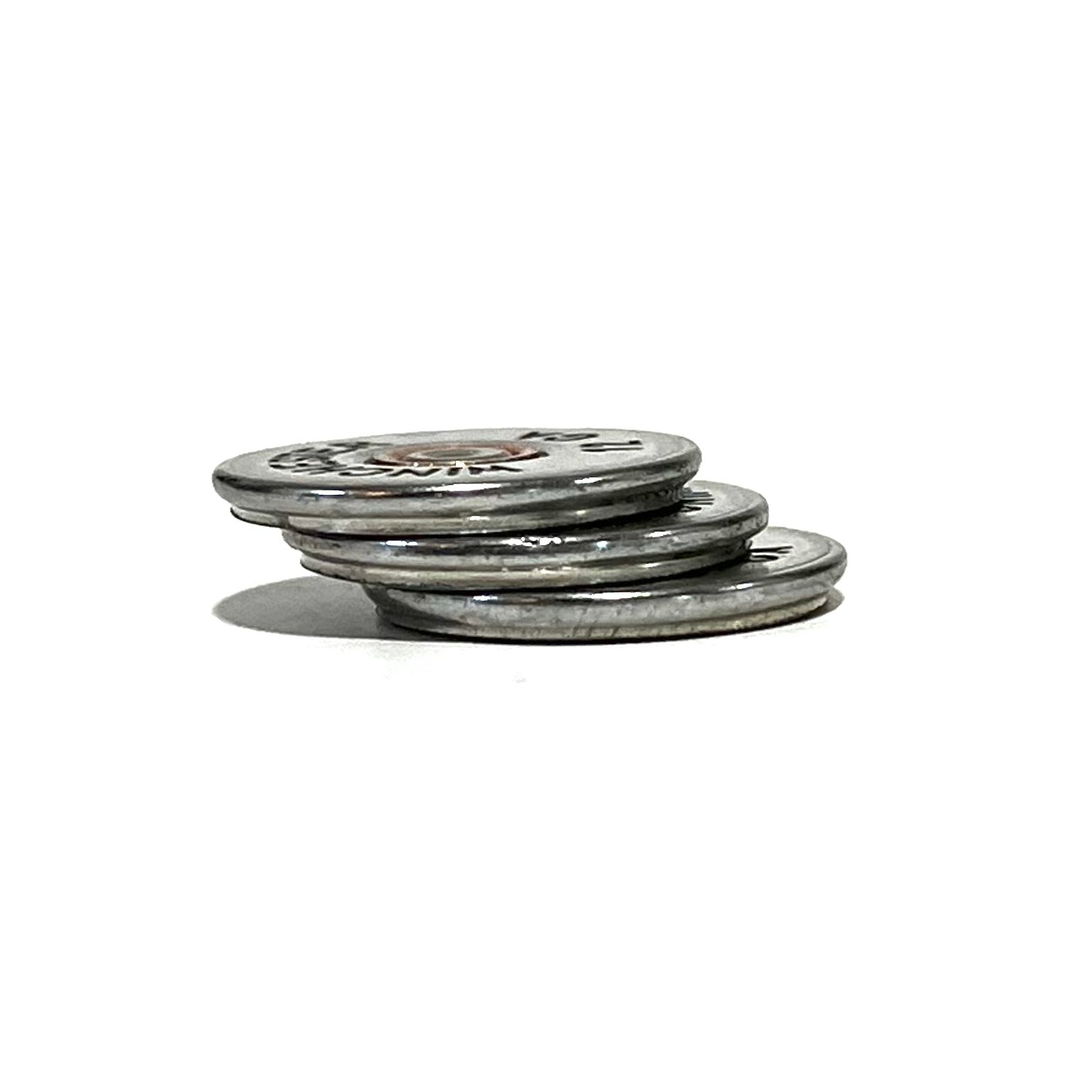 A stack of three silver, hand-painted bullet slices resting on a white background.