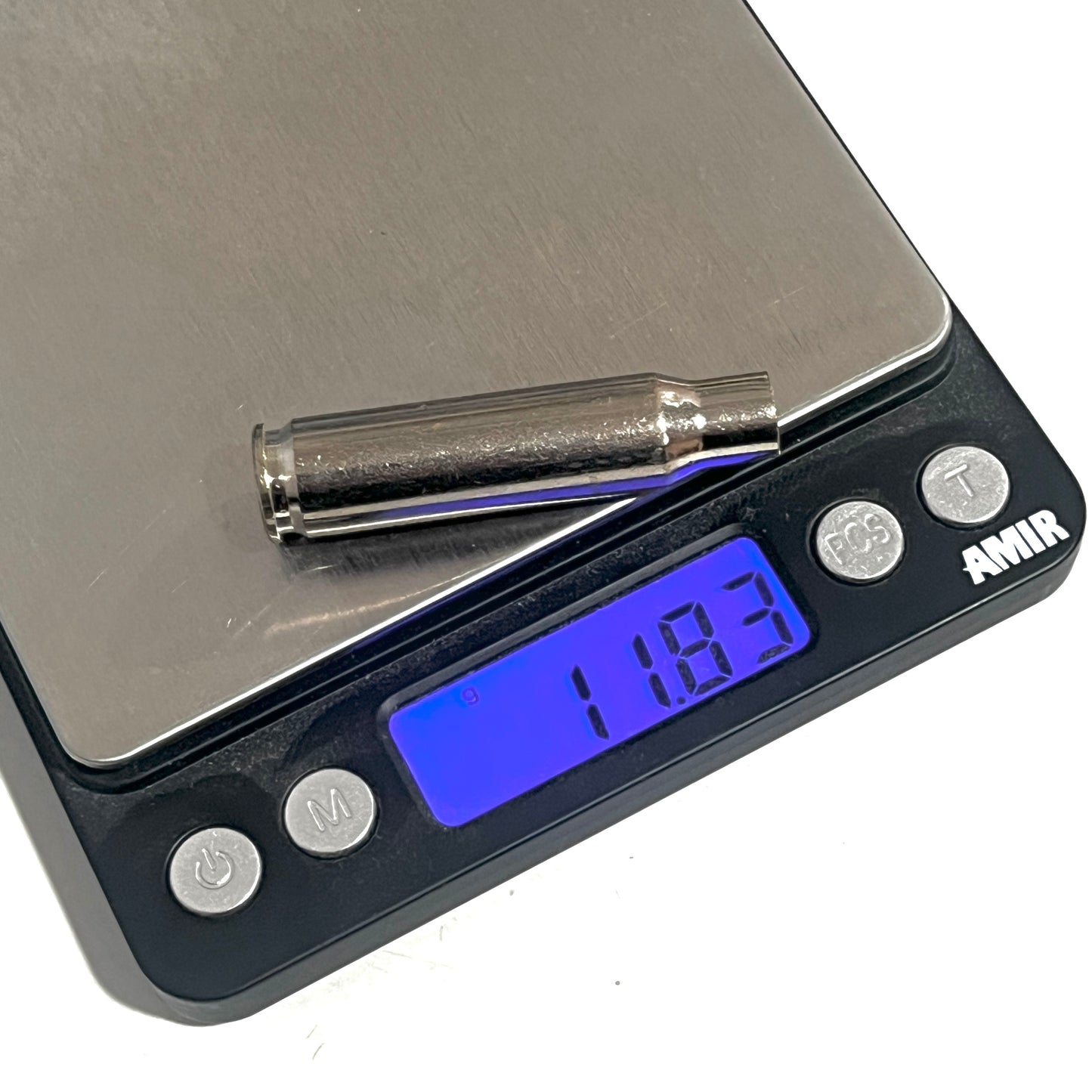 Single silver-tone .308 WIN spent casing resting on a digital pocket scale displaying 11.83 grams.
