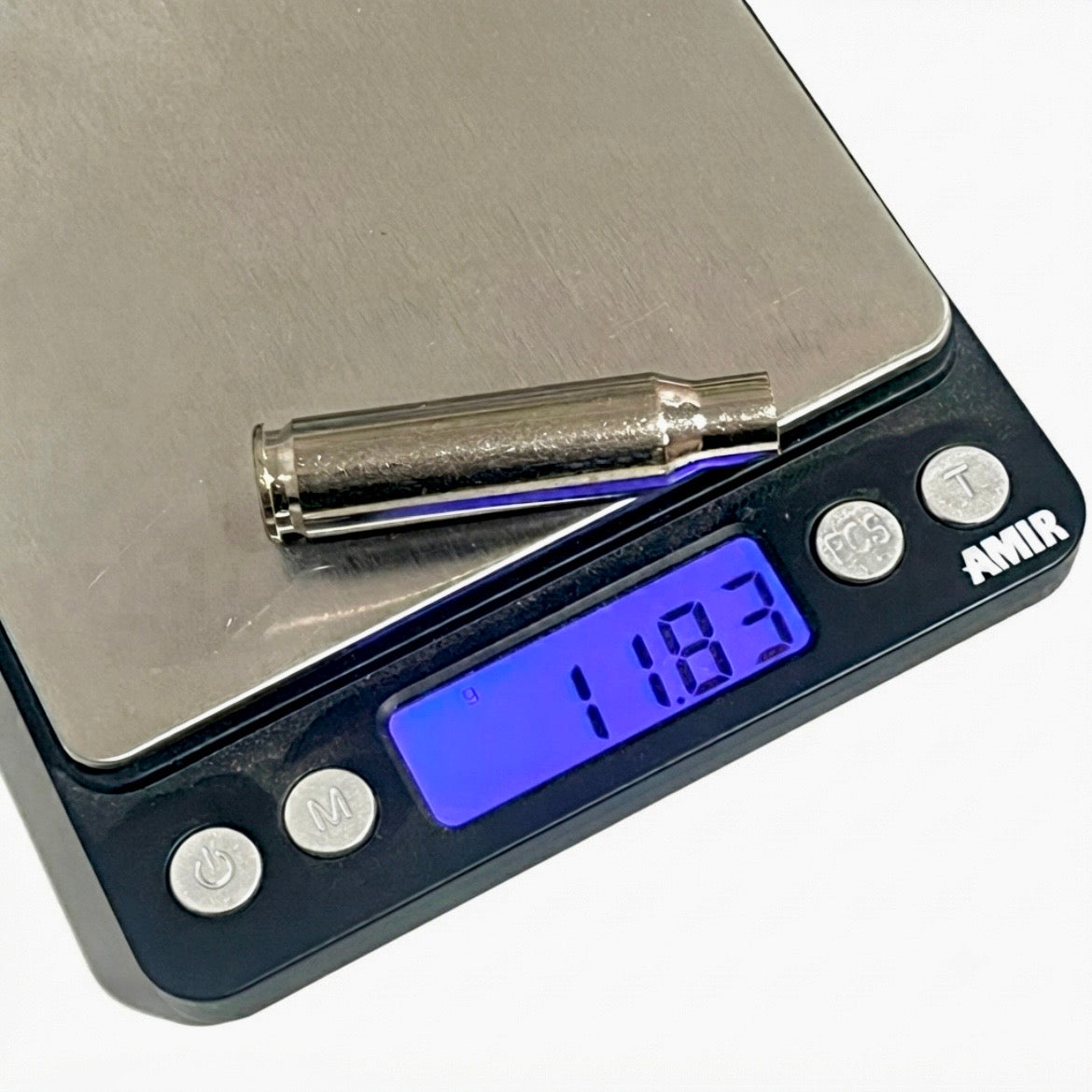 A real, recovered silver bullet casing resting on a digital pocket scale displaying 11.83 grams.