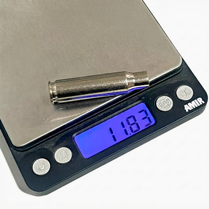 A real, recovered silver bullet casing resting on a digital pocket scale displaying 11.83 grams.