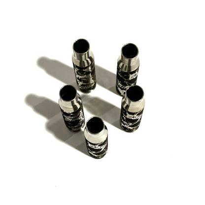 5 nickel .308 WIN cartridges engraved with a skull design, viewed from above showing open mouths