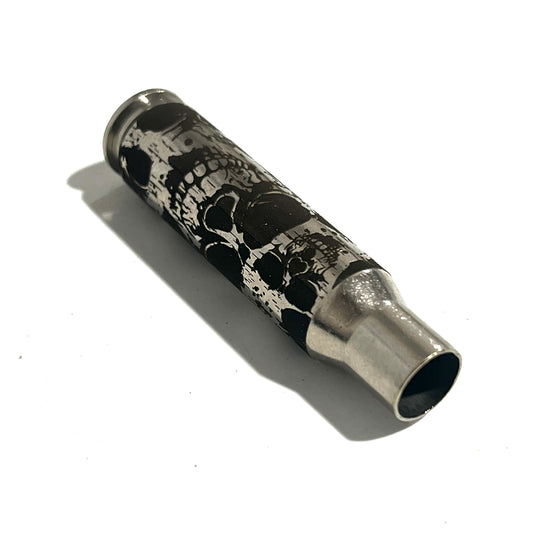 Nickel .308 WIN cartridge engraved with a skull design, lying on its side