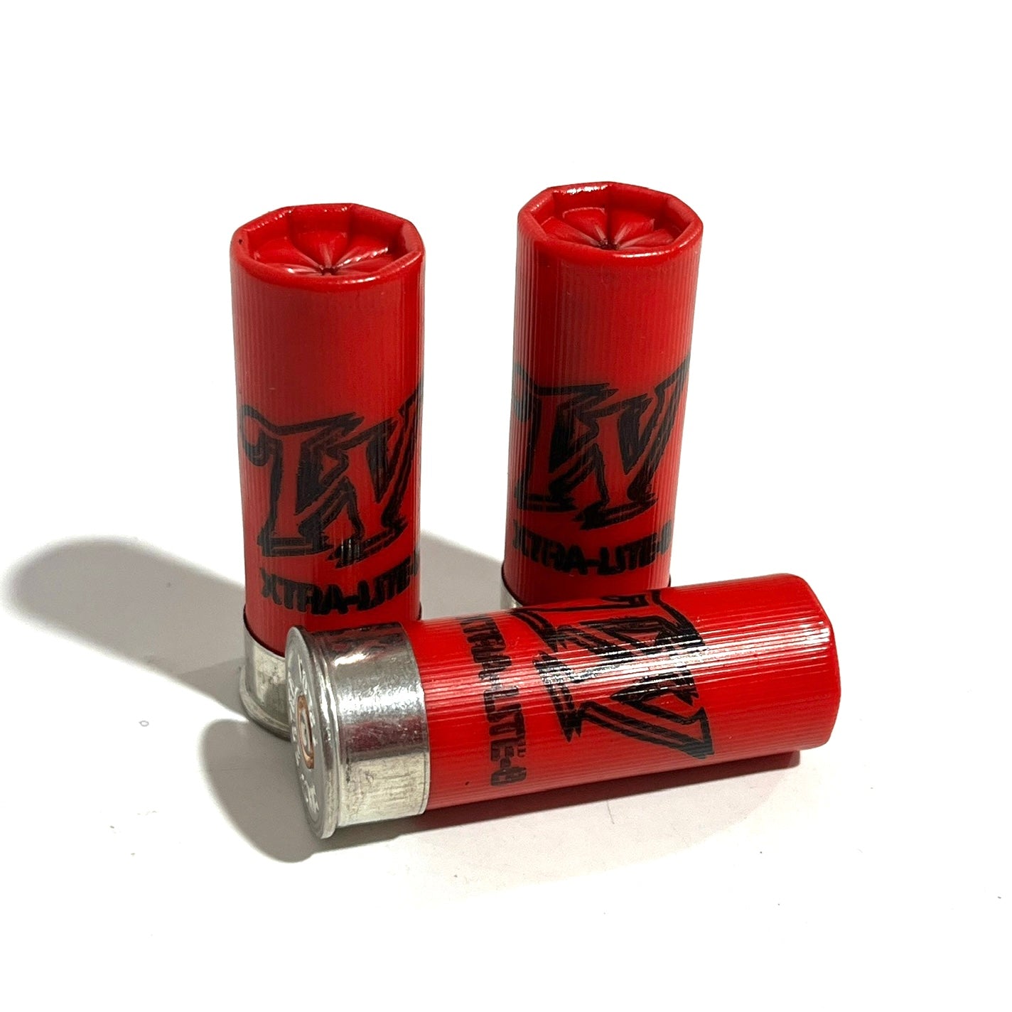 Three red spent cartridges with one lying down in front of two upright ones on a plain white surface.
