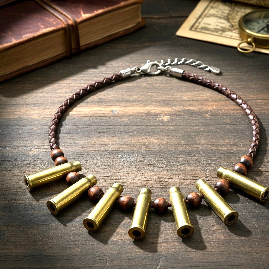 A necklace made of a braided brown leather cord, wooden beads, and 7 spent brass casings, laid on a rustic wooden table.