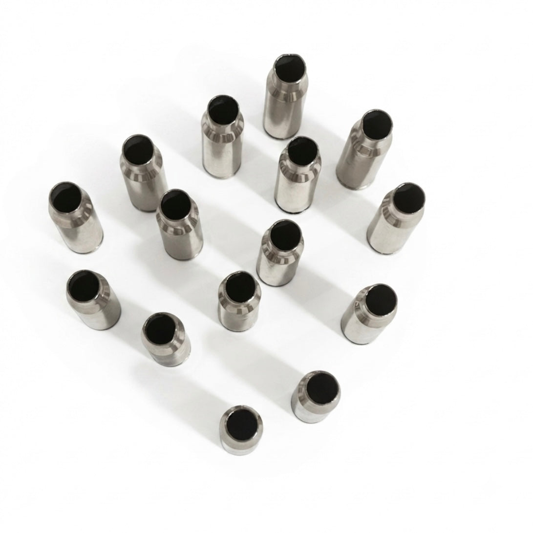 Staggered grid of thirteen empty silver .308 WIN casings standing upright on a white surface, open mouths facing up.