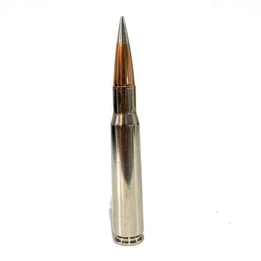 Standing 50 cal BMG dummy round with polished nickel-plated casing and copper match grade bullet tip.
