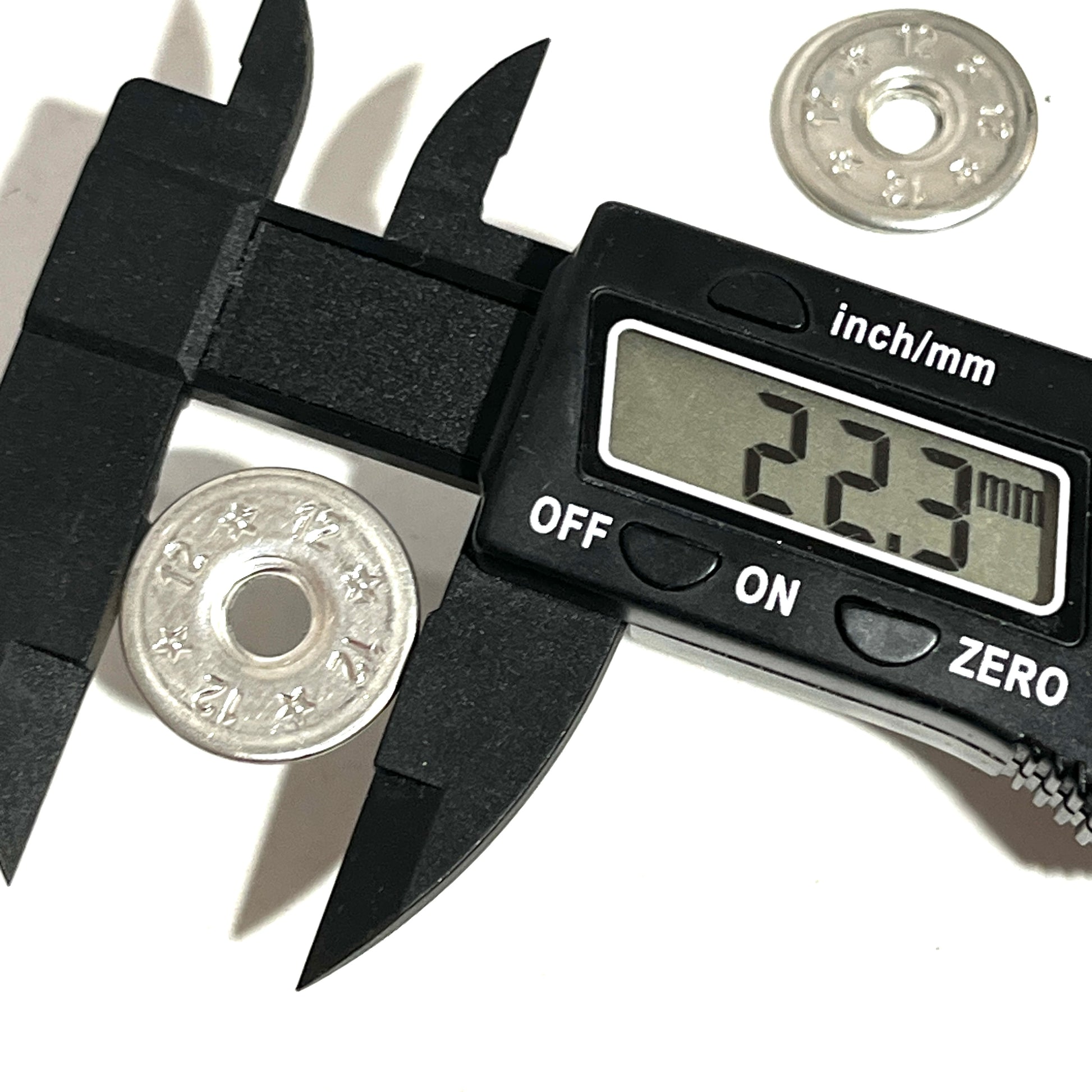 Digital caliper measuring the diameter of a flattened 12 gauge shotgun shell slice at 22.3mm