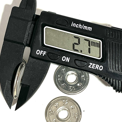 Digital caliper measuring the width of a flattened 12 gauge shotgun shell slice at 2.7mm, two more slices in background
