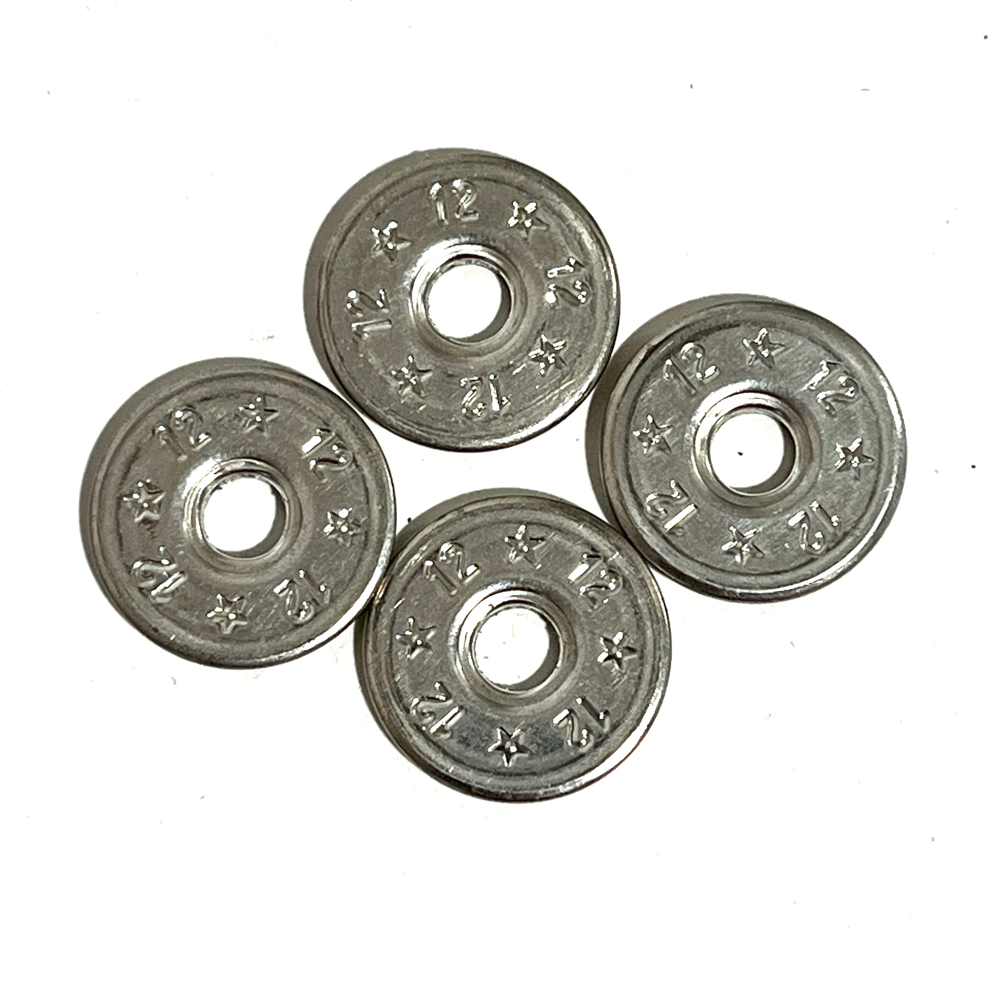 4 flattened silver 12 gauge shotgun shell slices arranged in a diamond pattern on white background, deprimed center holes
