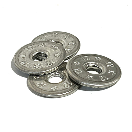 4 flattened silver 12 gauge shotgun shell slices stacked in a small pile, star and 12 embossed pattern, white background