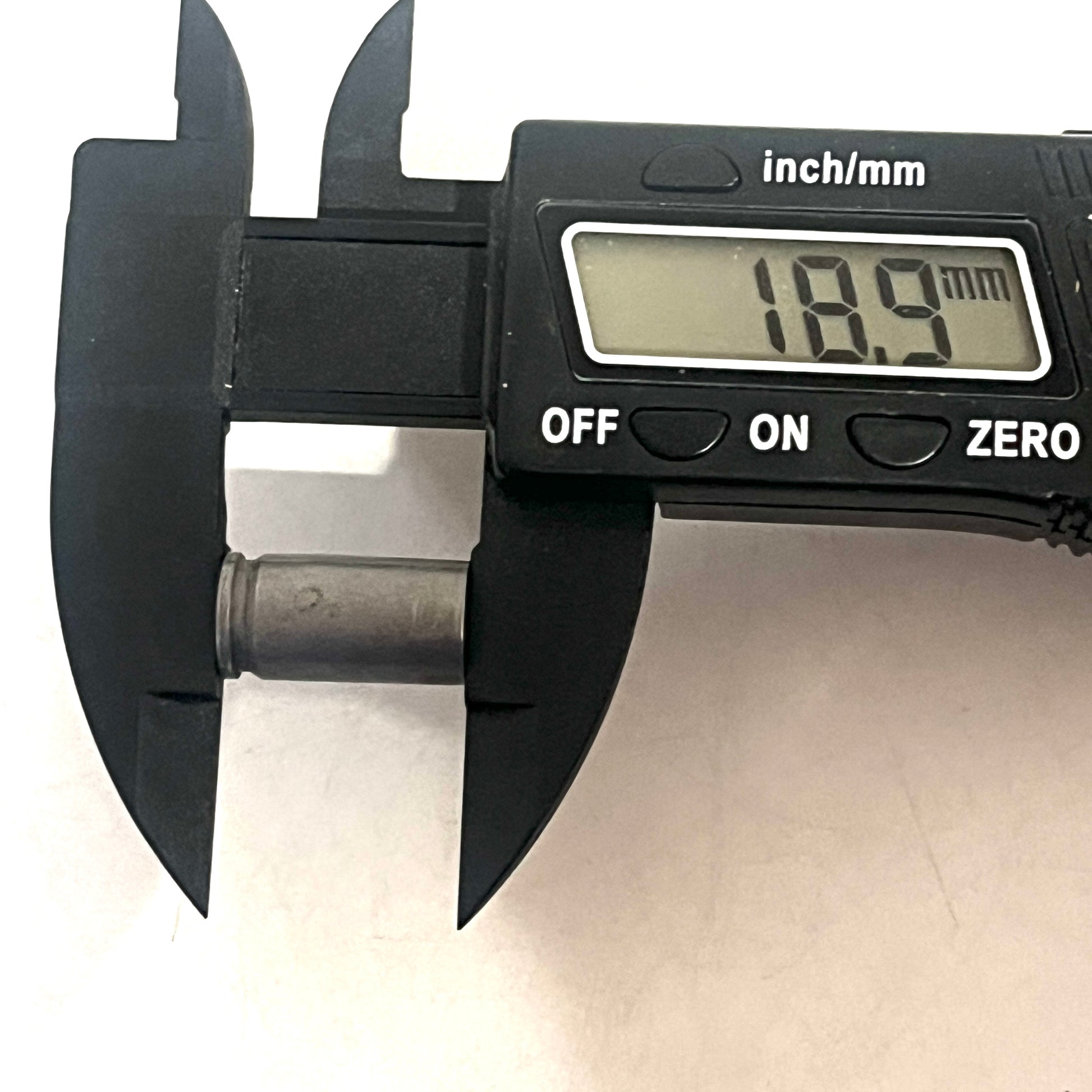 Digital caliper measuring the length of a steel 9mm casing at 18.9 millimeters