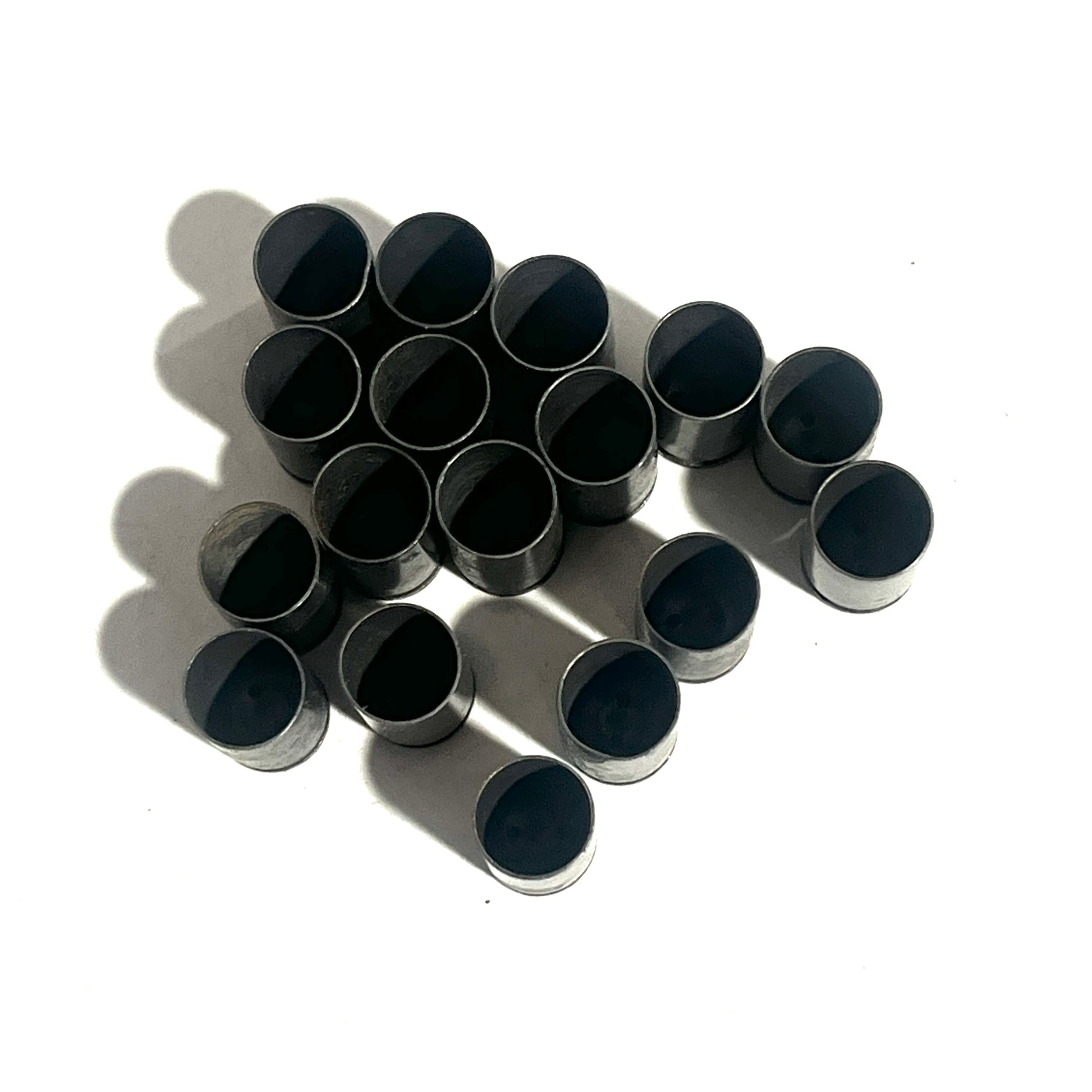 Fifteen dark steel 9mm empty casings viewed open-end up on a white background