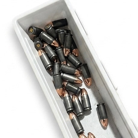 A large quantity of gray steel 9mm dummy cartridges piled in a white plastic tray