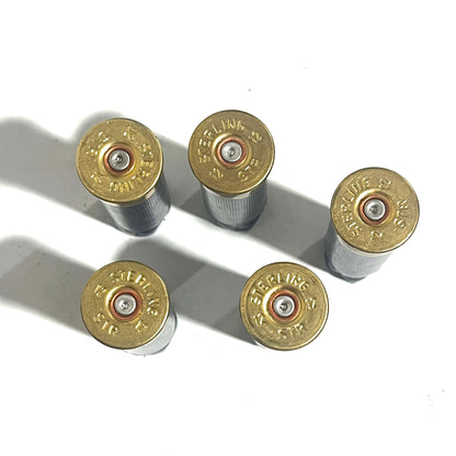 Five brass shell bases stamped STERLING 12GA, viewed from above with primers visible