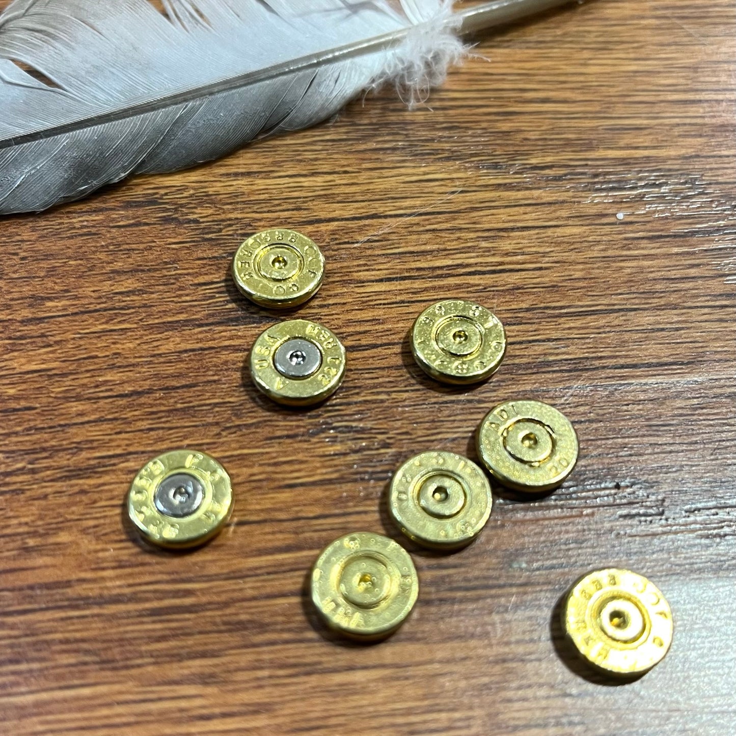 Lightweight, low-profile brass bullet casing slice measured with digital calipers for custom crafting.