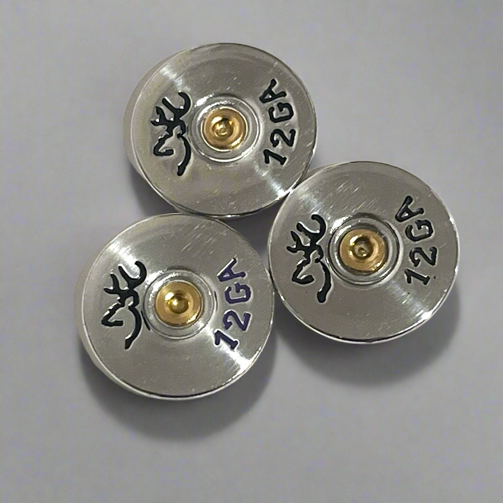 Three silver Browning 12 gauge shotgun shell slices arranged on a gray background