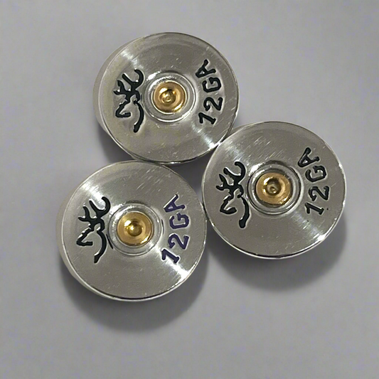 Three silver Browning 12 gauge shotgun shell slices arranged on a gray background