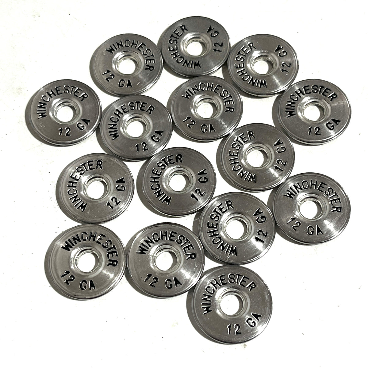Twelve silver Winchester 12 gauge shotgun shell painted slices arranged in a circular design on a white background.