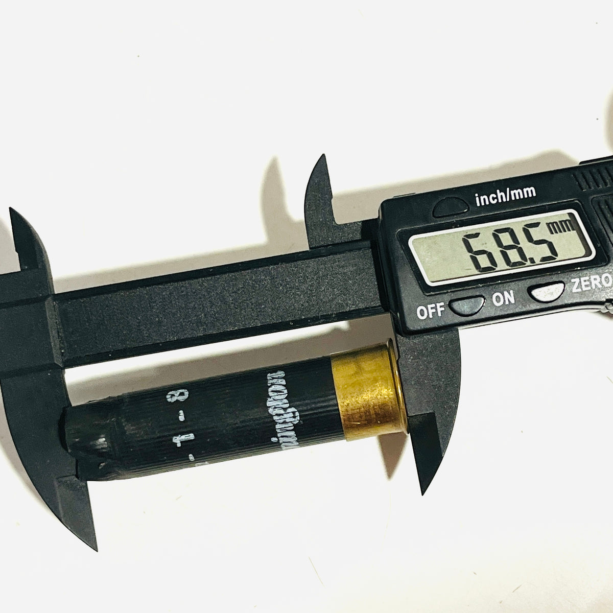Used black shotshell with brass base measured lengthwise by a digital caliper reading 68.5 mm