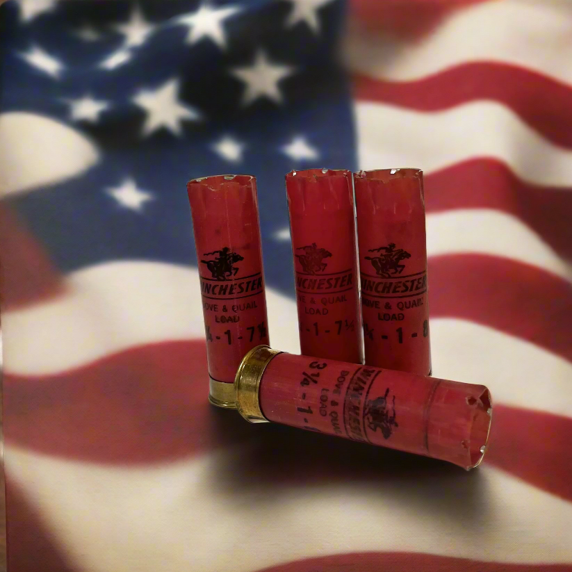 Four vintage red Winchester Horse and Rider 12 gauge shotgun shells on an American flag background