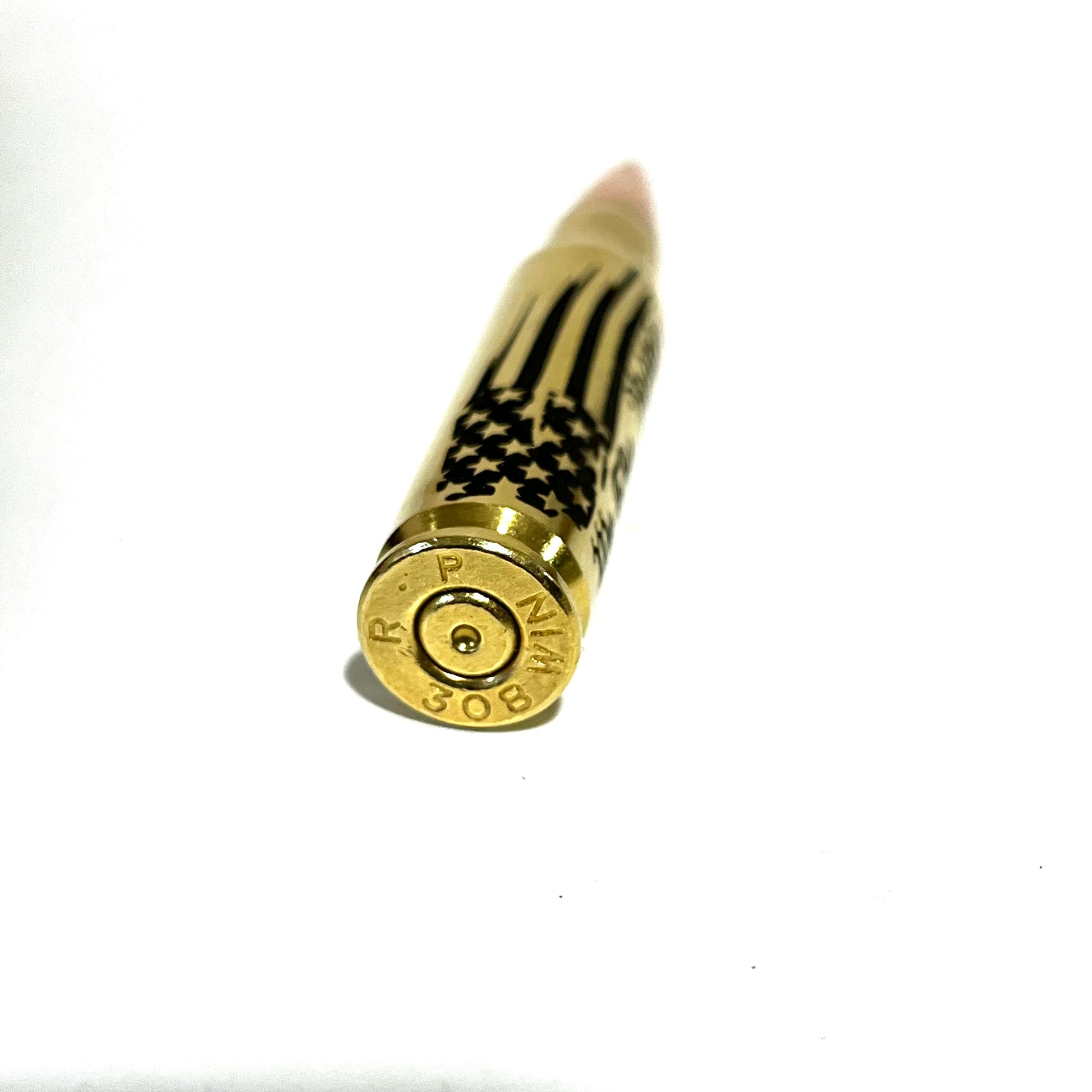 Close-up of a 'We The People' engraved .308 bullet's brass base showing headstamp, tip blurred