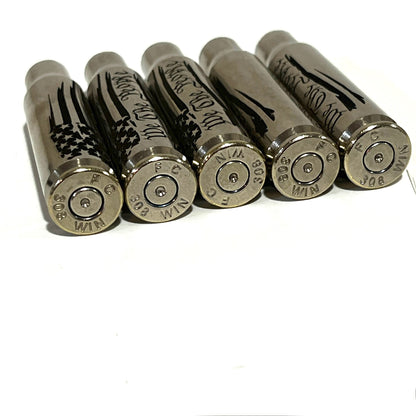 5 nickel .308 WIN cartridges engraved with We The People, lying on their sides showing headstamps reading 308 WIN