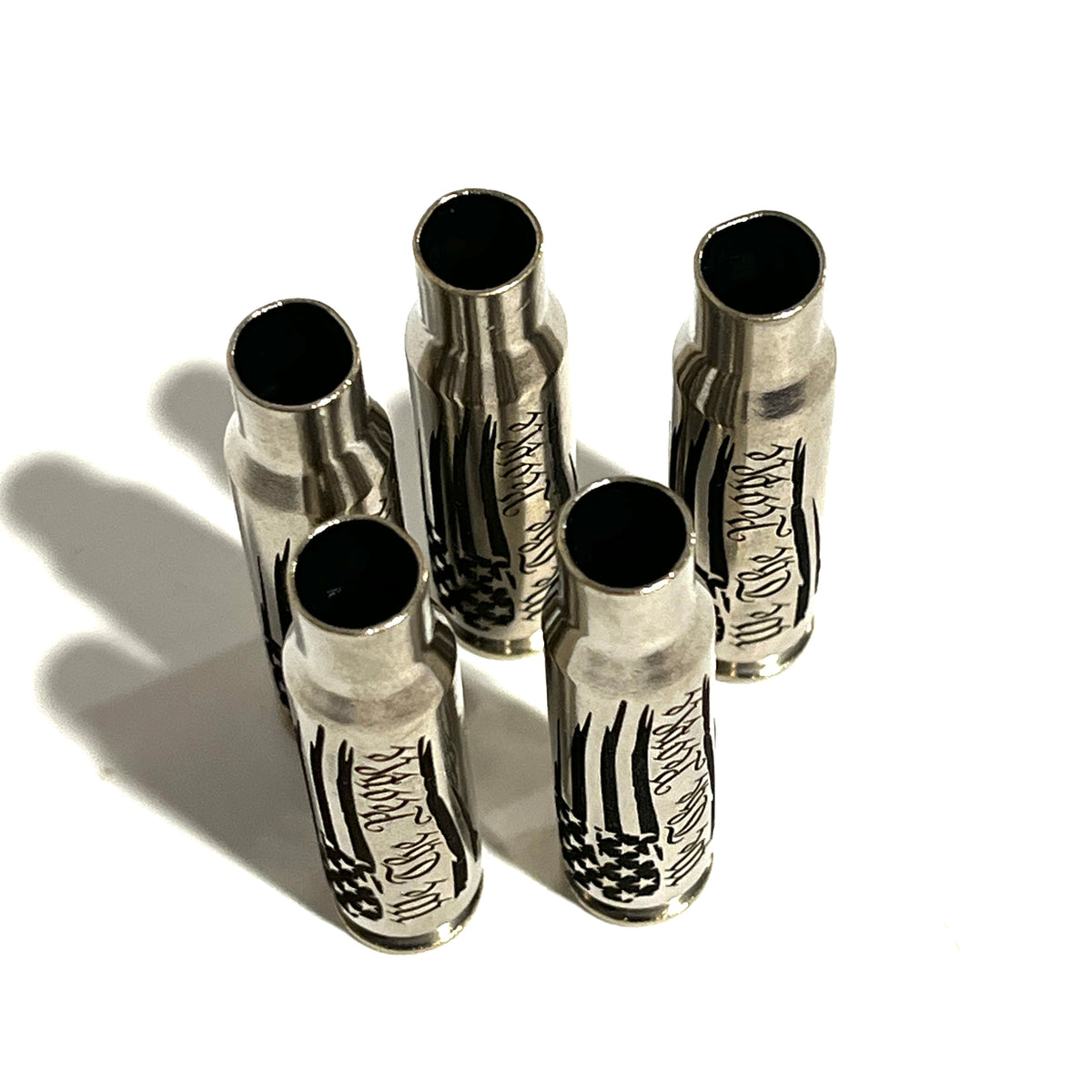 5 nickel .308 WIN cartridges engraved with We The People, standing with open mouths facing up
