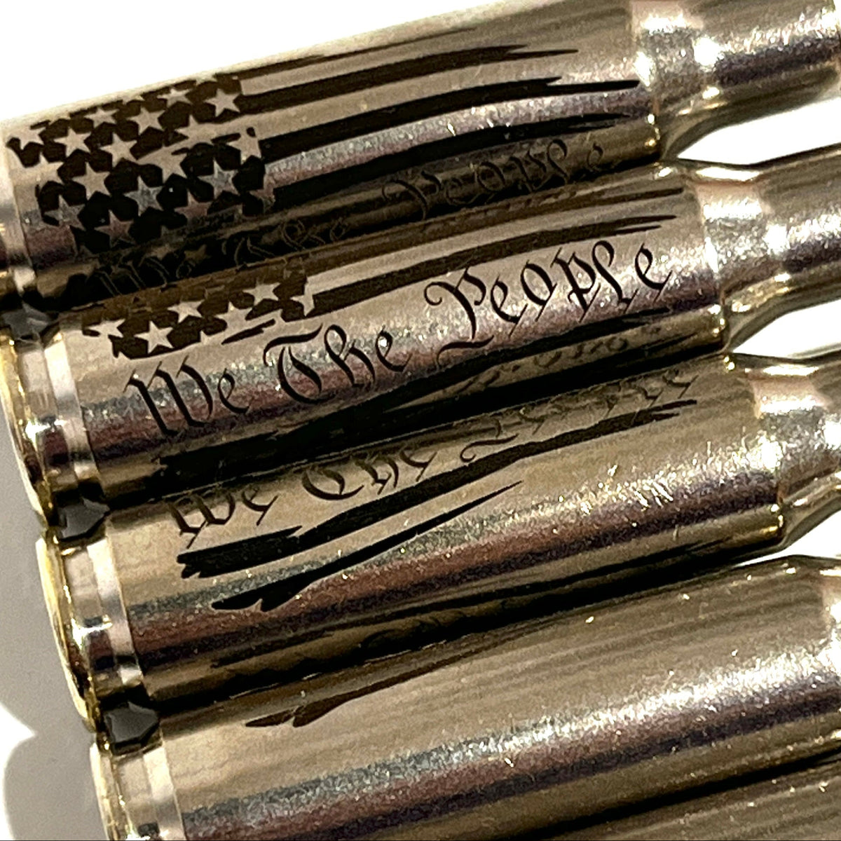 Close-up of We The People engraving and a star flag design on nickel .308 WIN cartridges