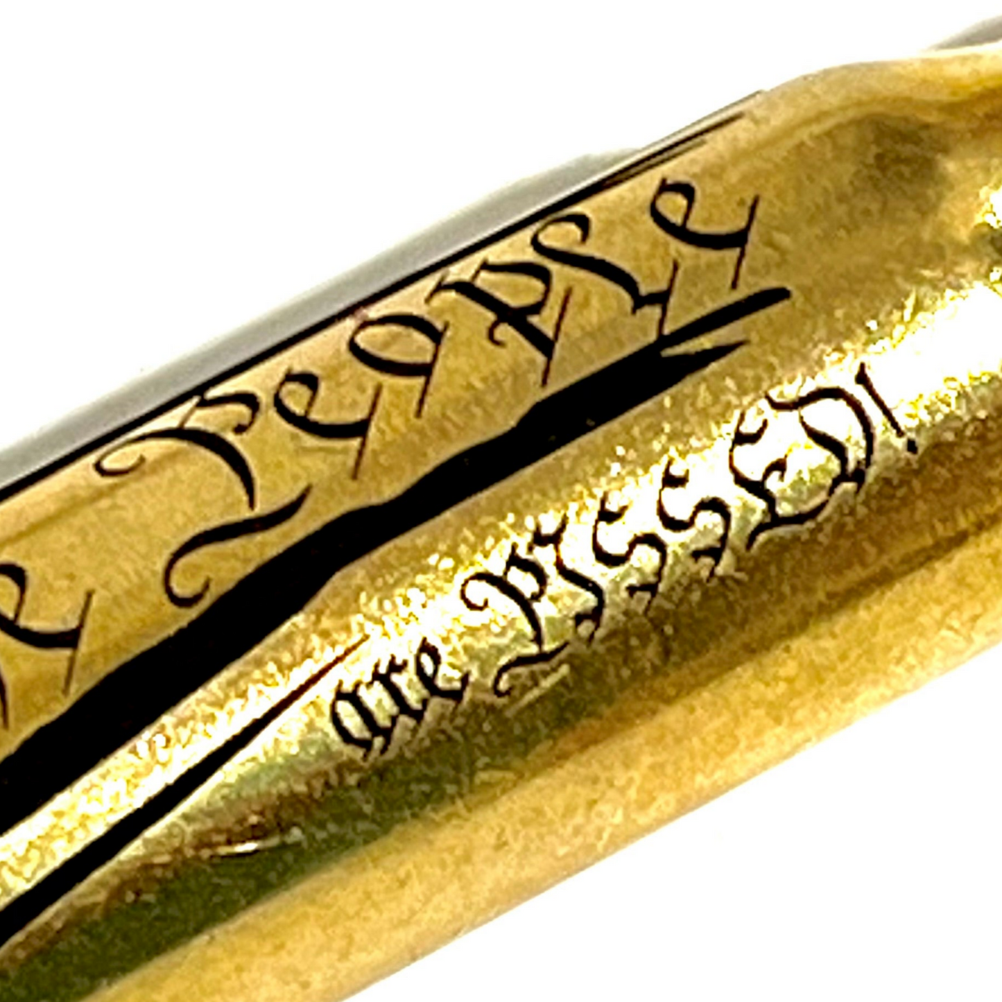 Extreme close-up of 'The People Are Pissed' engraving on a brass .308 WIN cartridge, alternate crop
