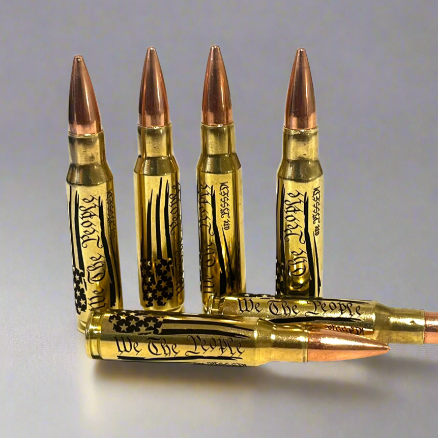 5 brass .308 WIN cartridges engraved with 'We The People Are Pissed' text and flag design on a gray background