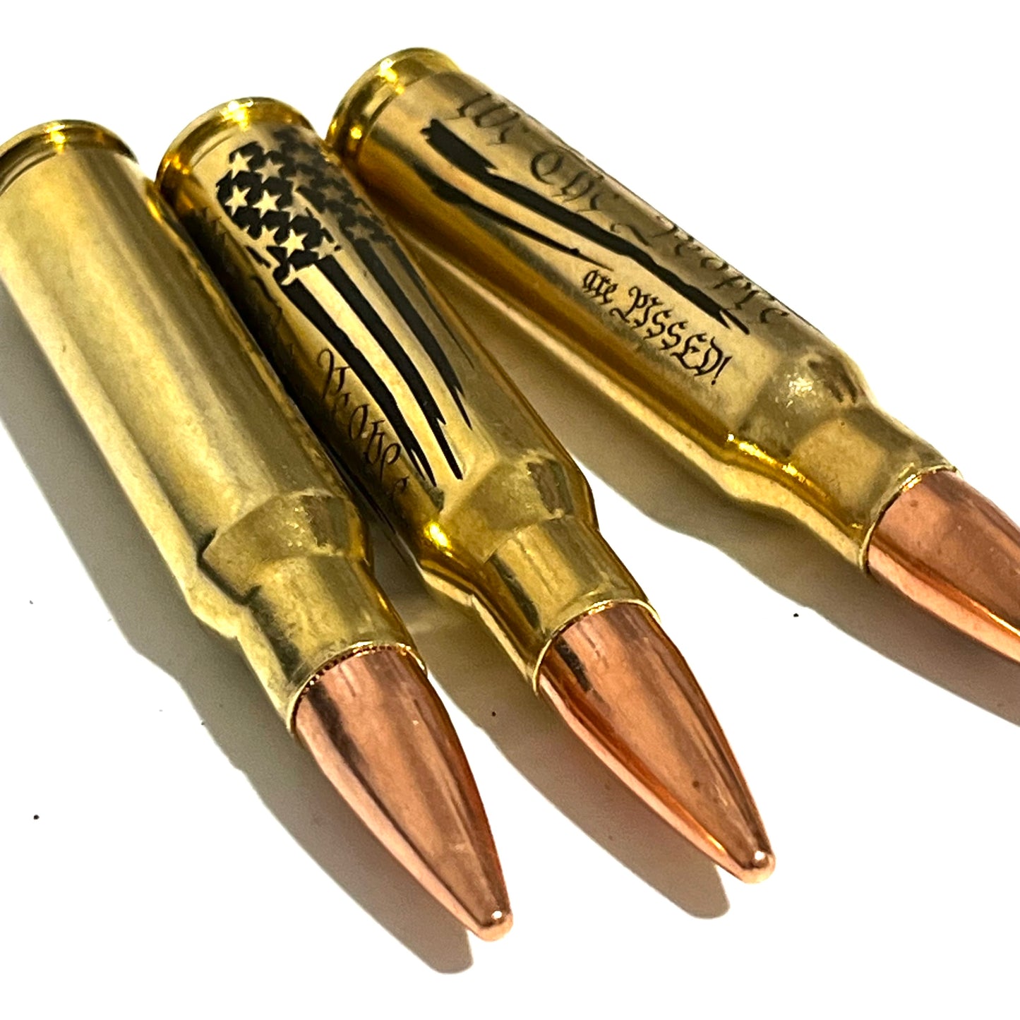 3 brass .308 WIN cartridges engraved with a flag design and 'We The People', headstamp visible, white background