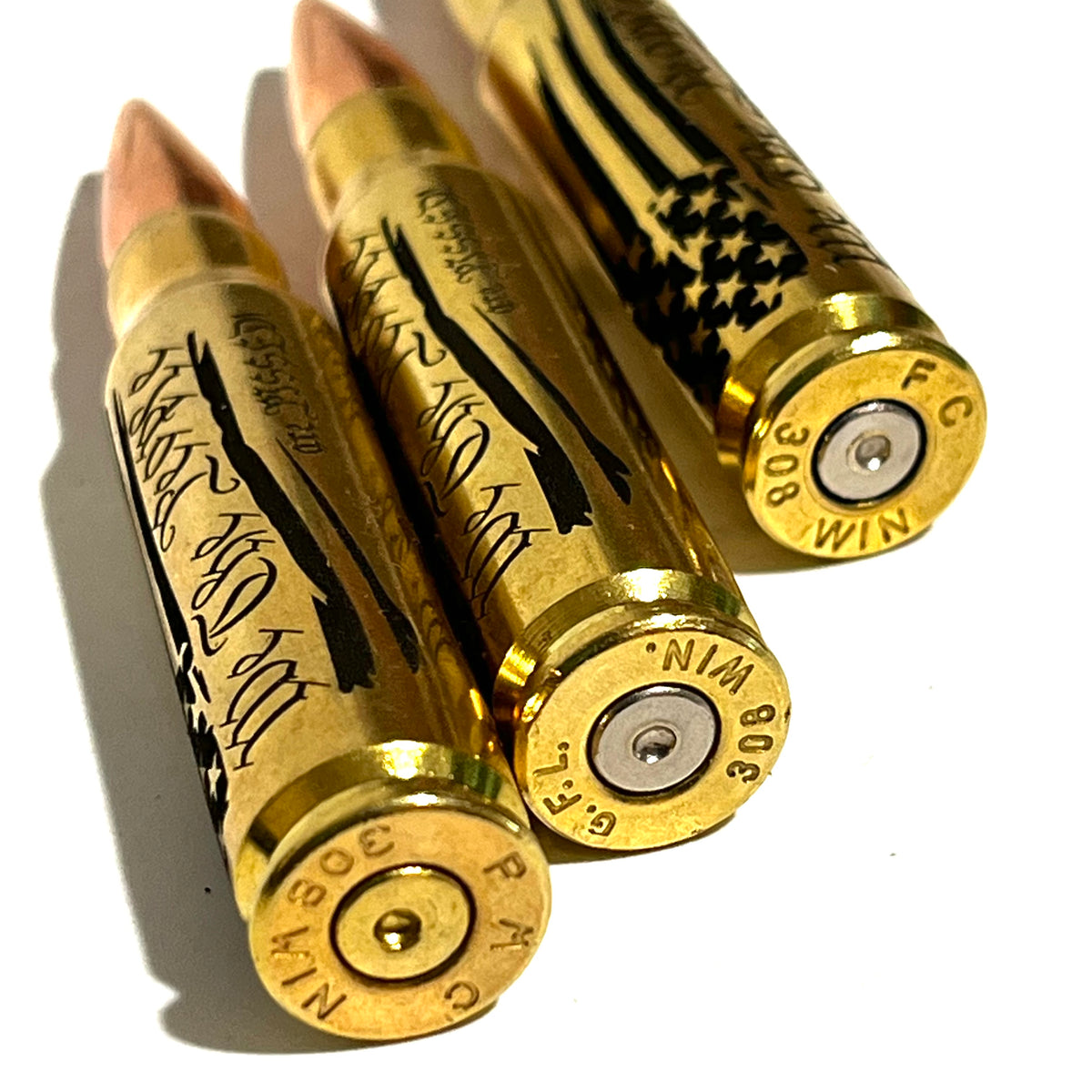 3 brass .308 WIN cartridges engraved with 'We The People Are Pissed' text, close-up