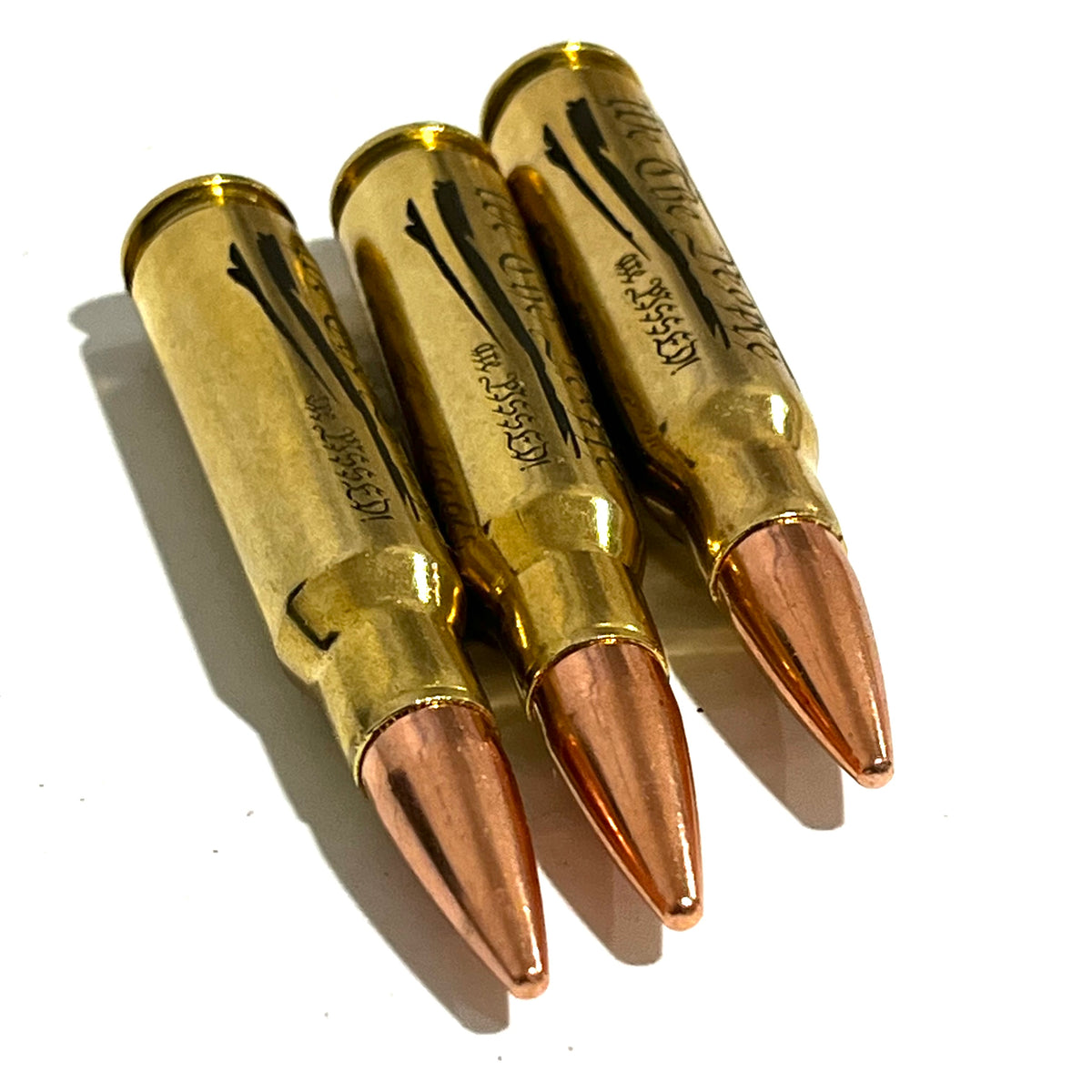 Close-up of a gloved hand holding a brass .308 WIN cartridge engraved with 'We The People Are Pissed'