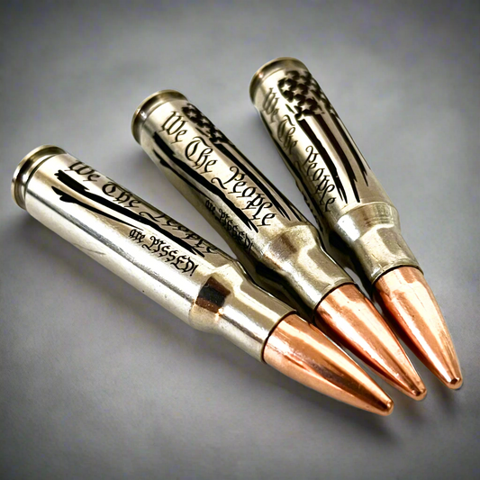 3 nickel .308 WIN cartridges with copper bullet tips engraved with We The People, We The People Are Pissed, and an American flag design