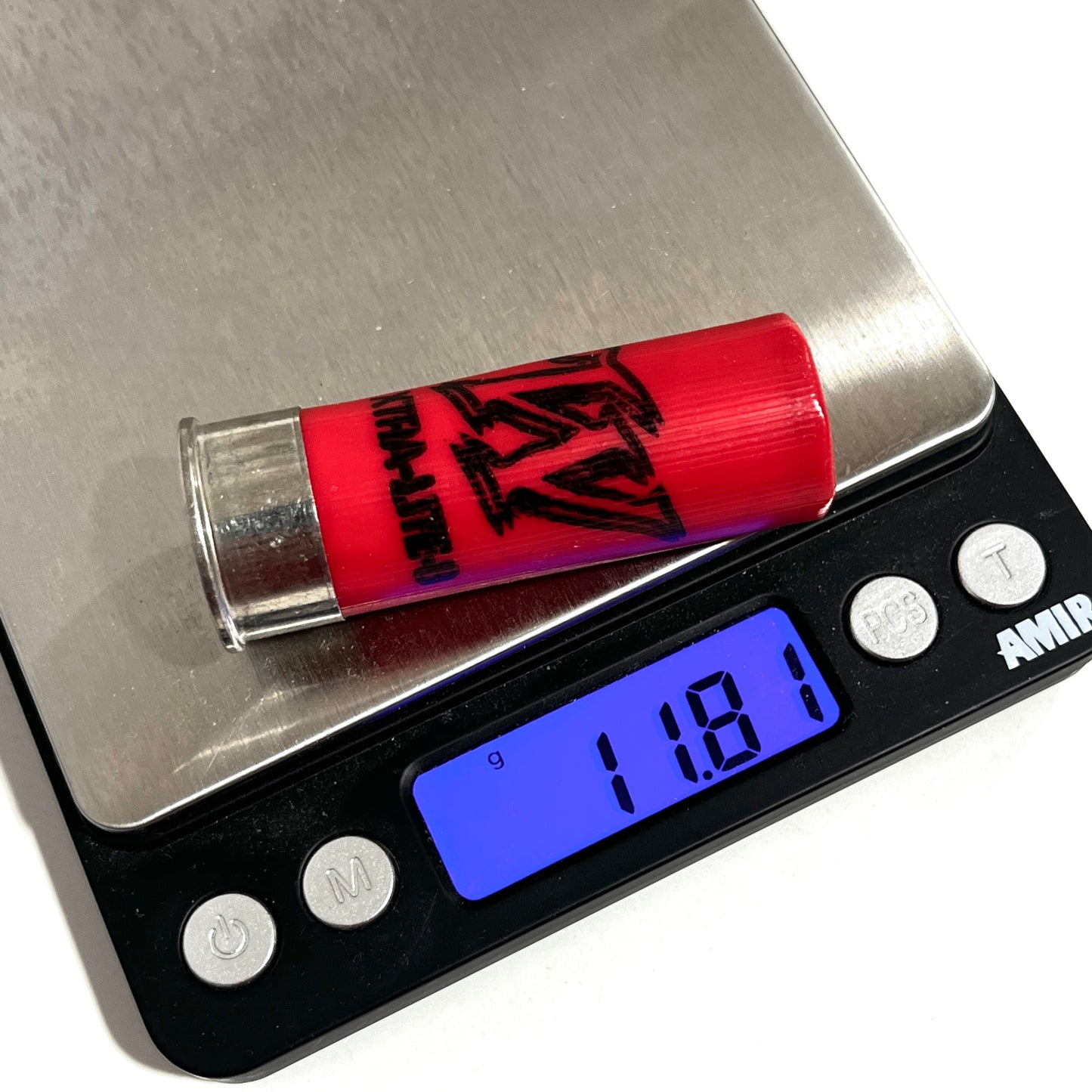 A red shotgun shell being weighed on a digital pocket scale showing a measurement of 11.8 grams.
