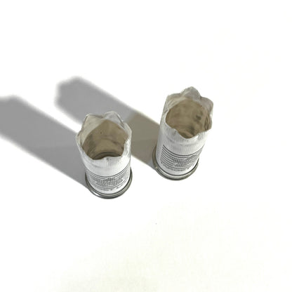 Two white 12 gauge empty shotgun shells viewed open-end up showing torn crimped mouths on a white background