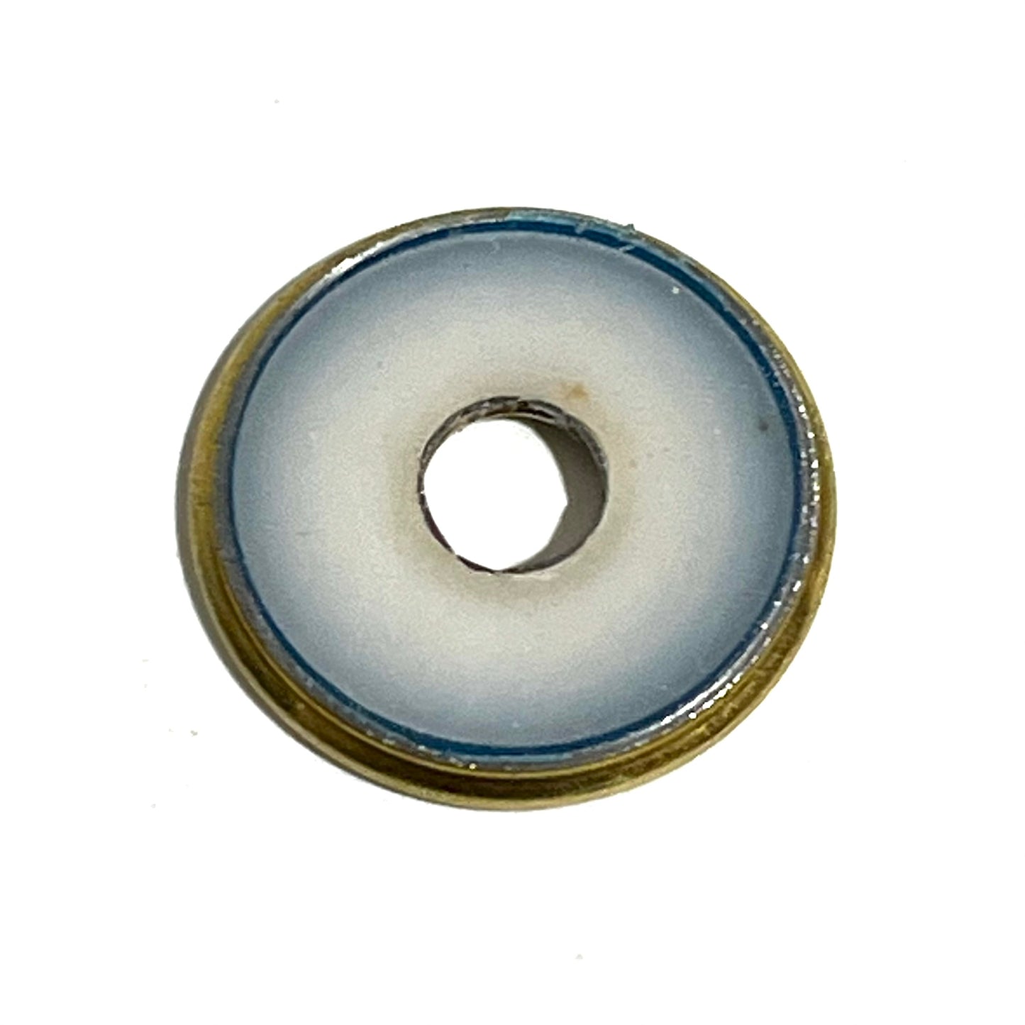 Close-up of a single deprimed 12 gauge shotgun shell slice showing a white plastic wad center ringed in brass