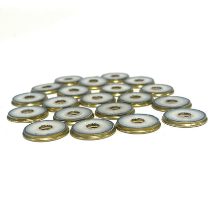 A cluster of deprimed 12 gauge shotgun shell slices showing white plastic wad centers ringed in brass, viewed at an angle