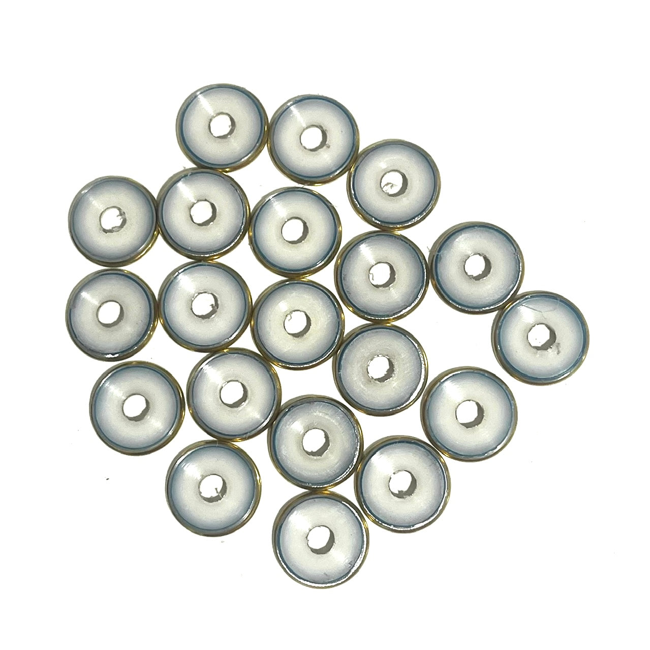 A cluster of deprimed 12 gauge shotgun shell slices showing white plastic wad centers ringed in brass, viewed from above
