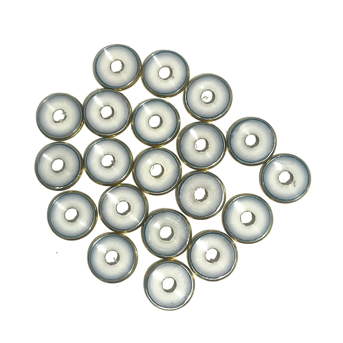 A cluster of deprimed 12 gauge shotgun shell slices showing white plastic wad centers ringed in brass, viewed from above