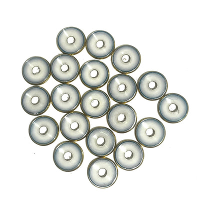 A cluster of deprimed 12 gauge shotgun shell slices showing white plastic wad centers ringed in brass, viewed from above