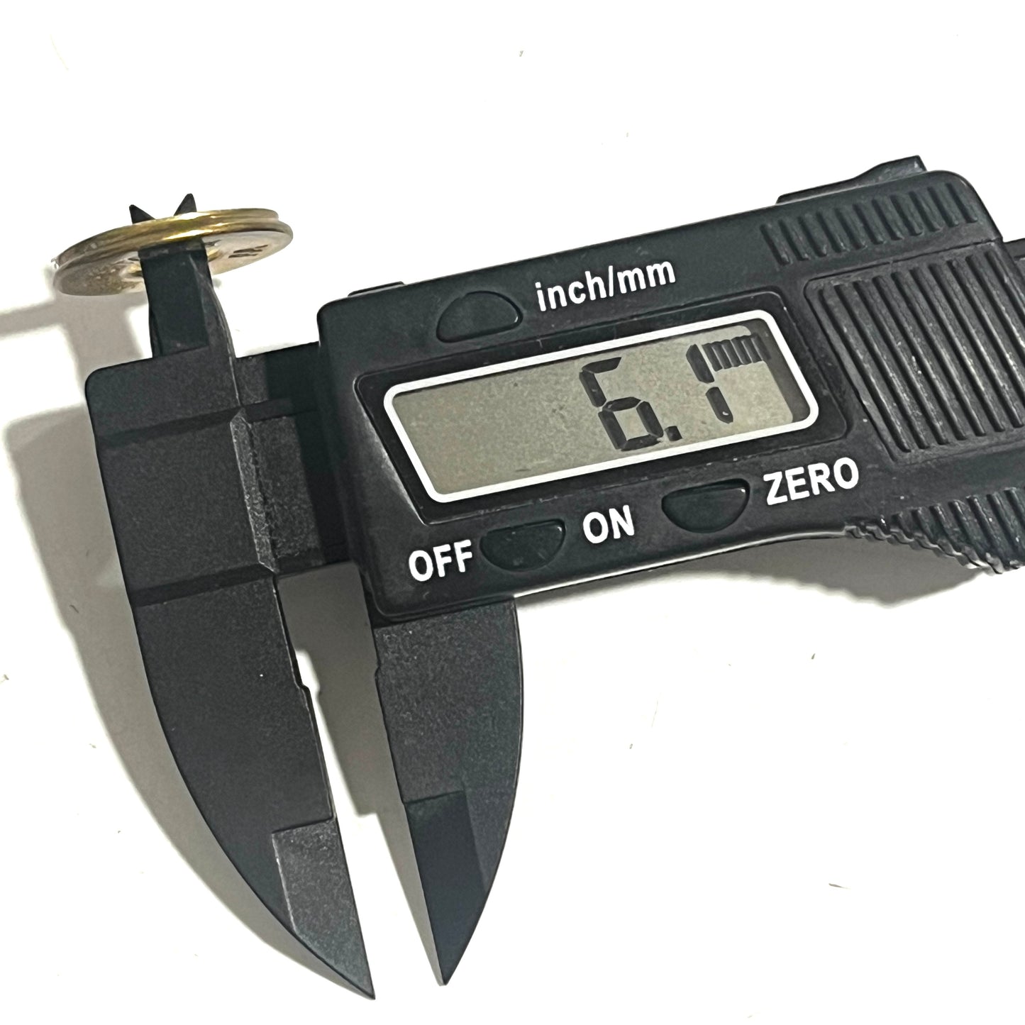 A digital caliper measures the center hole of an empty gold slice, reading 6.1 mm.