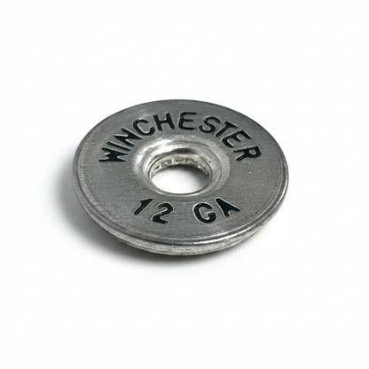 A close-up of a silver Winchester 12 gauge headstamp with black lettering on a white background.