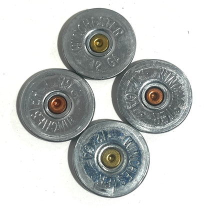 Four silver Winchester 12 gauge shotgun shell slices showing gold and copper primers