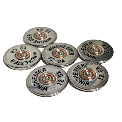 Six silver Winchester 12 gauge painted bullet slices arranged in a flat overhead cluster.