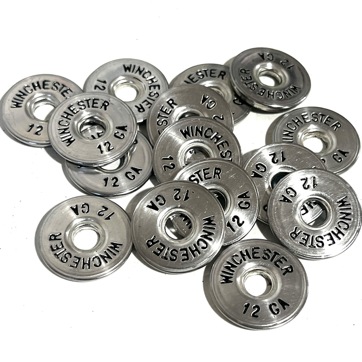 A scattered collection of silver Winchester hull slices with black lettering on a clean white background.
