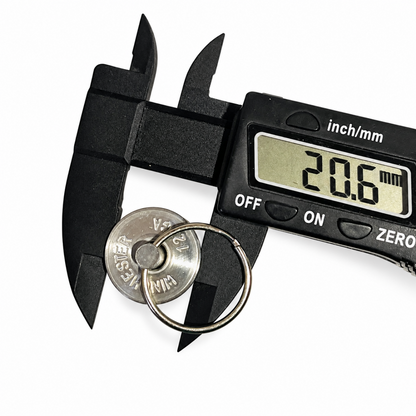 Caliper reading 20.6 mm across the WINCHESTER 12 headstamp diameter of a spent casing keychain