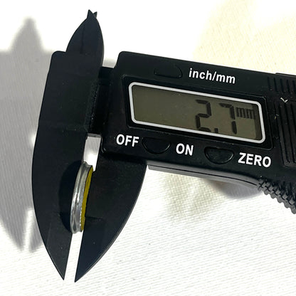 Digital caliper measuring the thickness of a shotgun shell slice at 2.7 millimeters