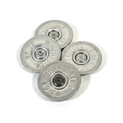 Four silver 20 gauge Winchester shotgun shell slices with visible primers arranged in a cluster on a white background